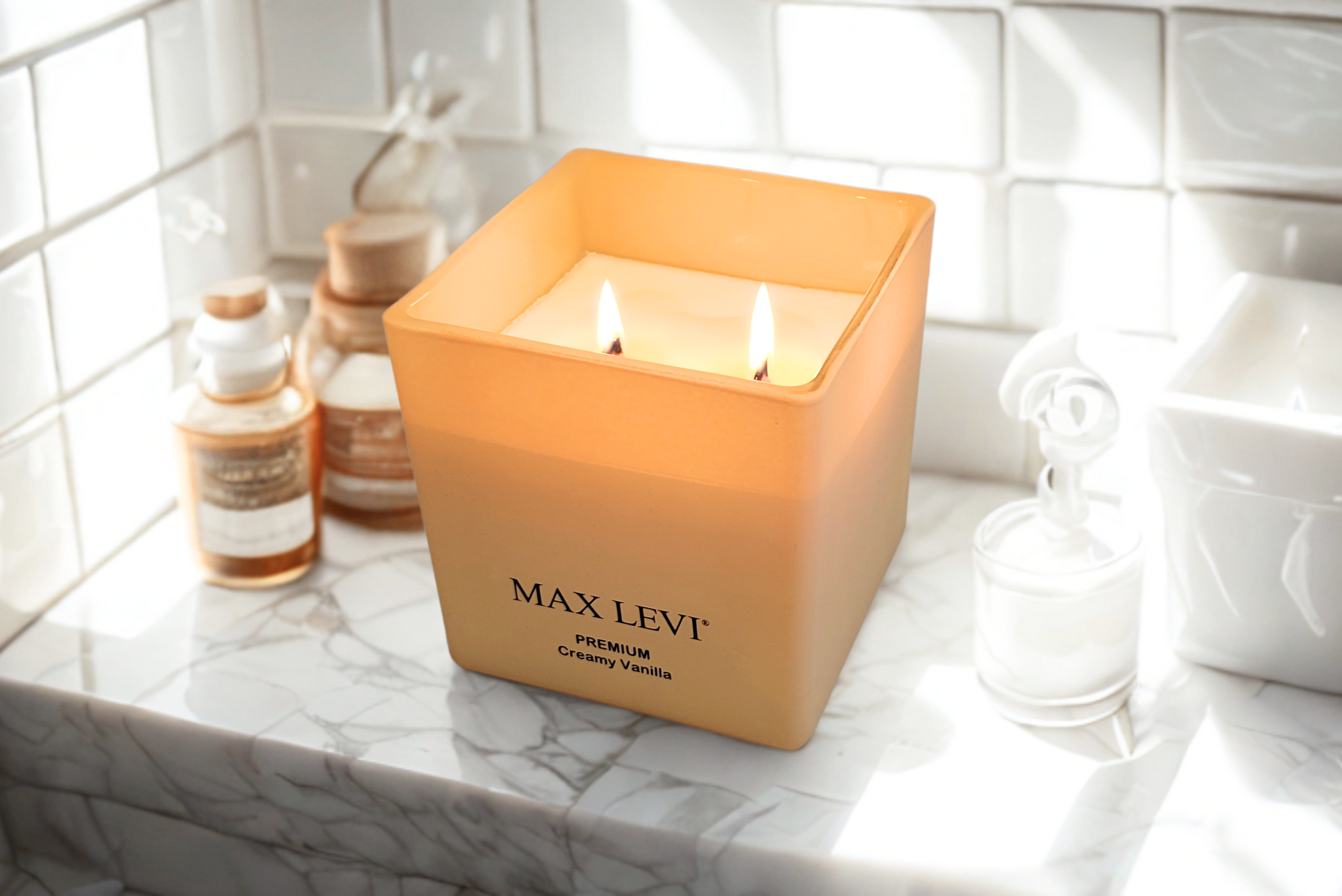 Max Levi Premium Creamy Vanilla Candle lit up, on a bathroom shelf.